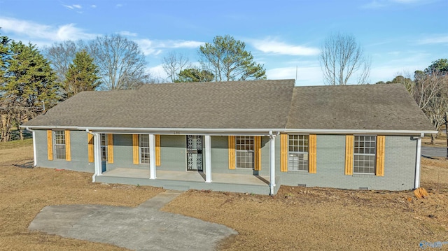 ranch-style home with a shingled roof, covered porch, brick siding, and crawl space