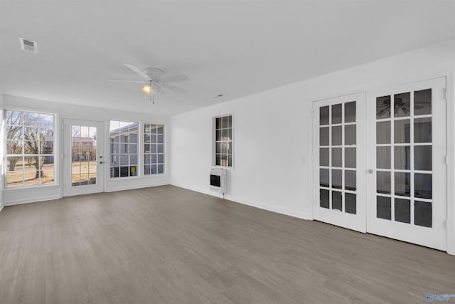 unfurnished sunroom with heating unit, ceiling fan, and visible vents