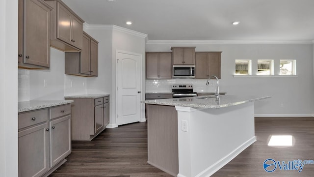 kitchen featuring ornamental molding, a center island with sink, stainless steel appliances, dark hardwood / wood-style flooring, and sink