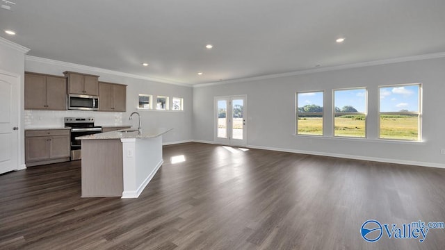 kitchen with stainless steel appliances, dark wood-type flooring, light stone countertops, and a kitchen island with sink