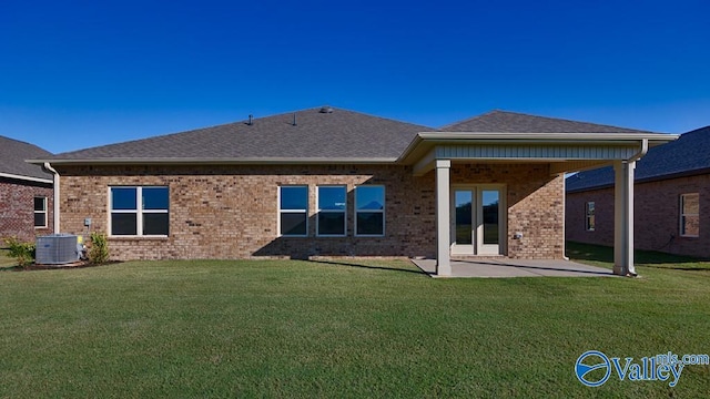 rear view of property featuring french doors, cooling unit, a patio, and a yard