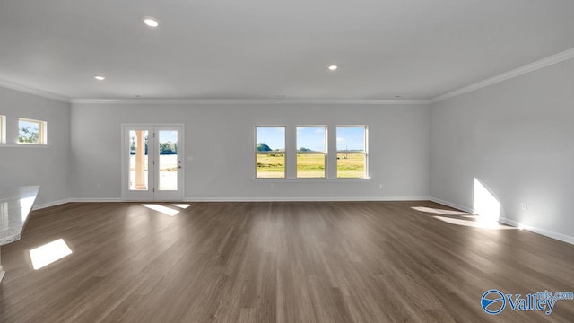 empty room featuring dark hardwood / wood-style flooring, a wealth of natural light, and ornamental molding