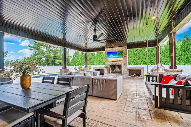 20009 Capitol Hill Dr, Tanner, AL 35671 - fenced backyard with a patio area, outdoor dining area, ceiling fan, and an outdoor living space with a fireplace
