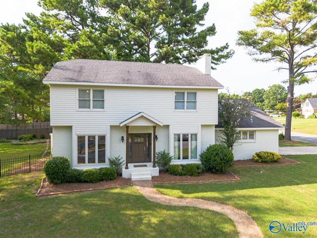 colonial-style house featuring a front yard