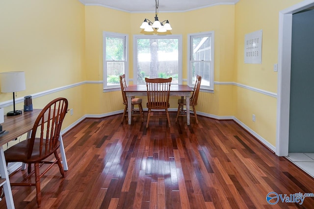 dining space with crown molding, hardwood / wood-style floors, and a chandelier