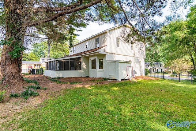 back of property featuring a sunroom and a yard