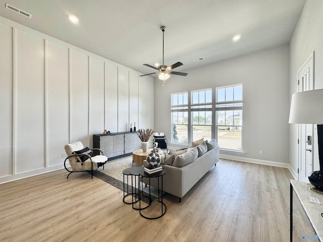 living room with light wood-type flooring and ceiling fan