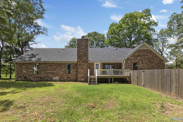 back of property with roof with shingles, fence, a wooden deck, crawl space, and a yard
