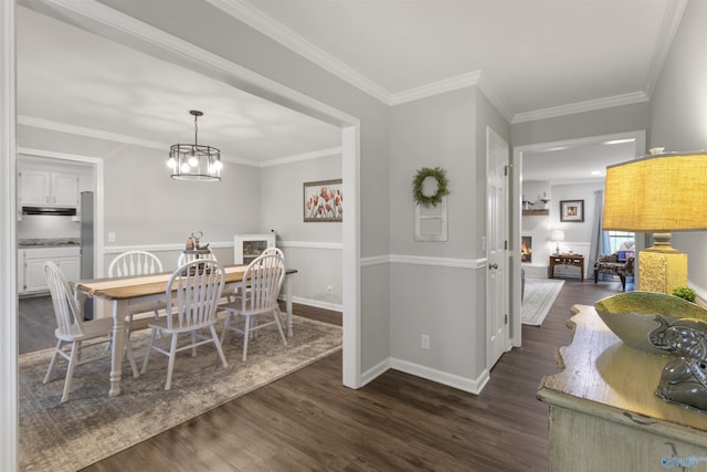 dining area featuring baseboards, an inviting chandelier, crown molding, and dark wood finished floors