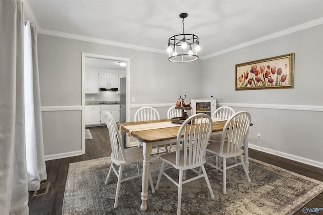 dining space featuring dark wood-style floors, a notable chandelier, crown molding, and baseboards