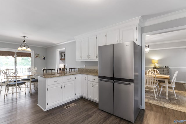 kitchen featuring dark wood-style flooring, visible vents, freestanding refrigerator, white cabinets, and a peninsula