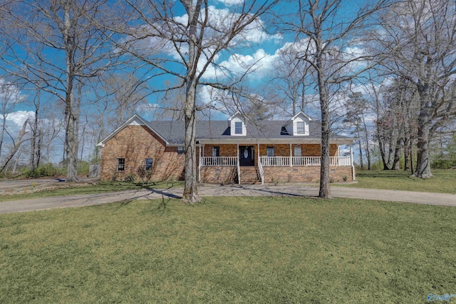 view of front of home with a front lawn, a porch, brick siding, and concrete driveway