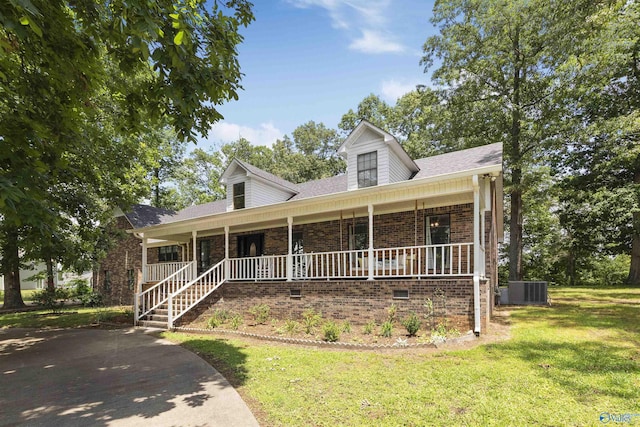 cape cod home featuring brick siding, central AC unit, a porch, and a front yard