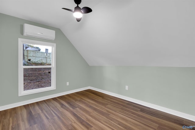 additional living space with lofted ceiling, hardwood / wood-style floors, a wall mounted AC, and ceiling fan