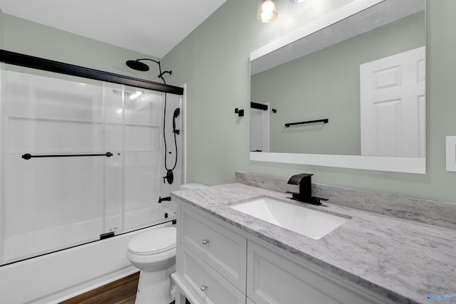 full bathroom with vanity, enclosed tub / shower combo, hardwood / wood-style flooring, and toilet