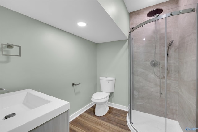 bathroom with toilet, walk in shower, vanity, and wood-type flooring