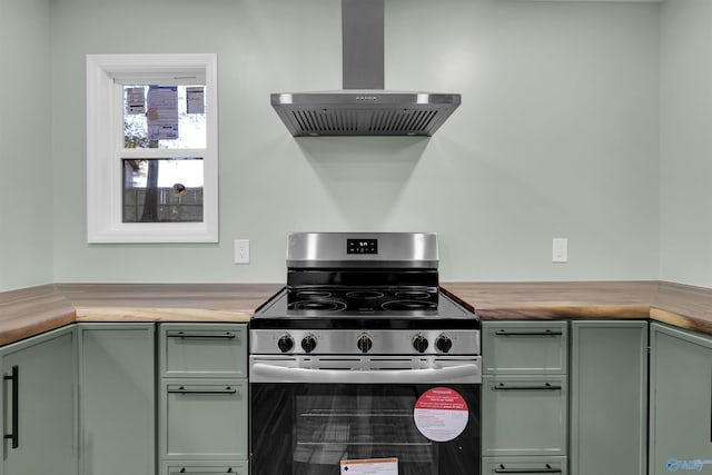 kitchen featuring wood counters, stainless steel range with gas cooktop, green cabinetry, and ventilation hood