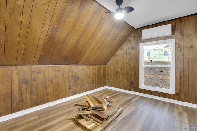 bonus room featuring hardwood / wood-style floors, a wall mounted AC, ceiling fan, vaulted ceiling, and wooden walls