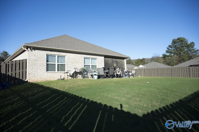 back of house featuring a lawn and a patio area