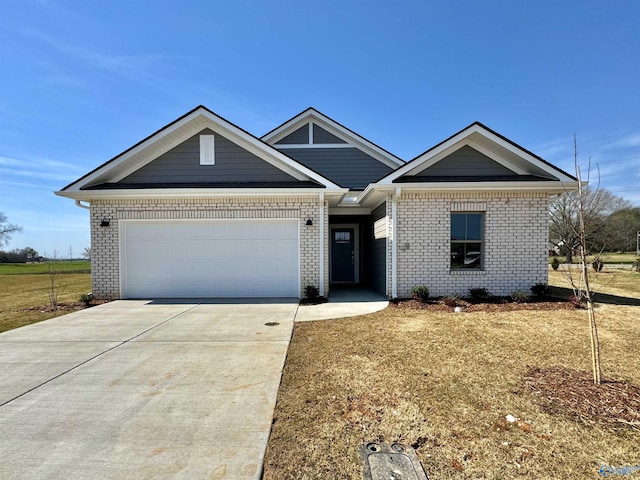 view of front of property featuring brick siding, driveway, and a garage