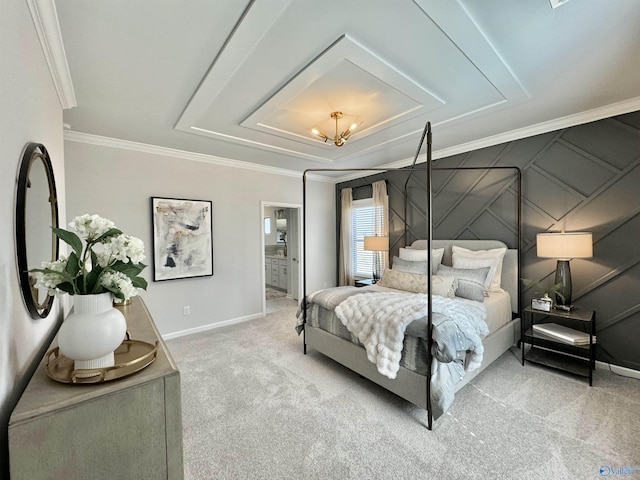 carpeted bedroom featuring connected bathroom, baseboards, ornamental molding, a decorative wall, and a raised ceiling