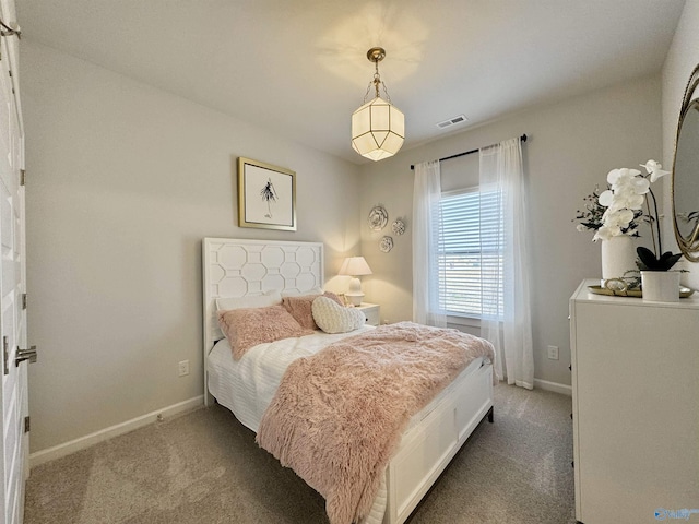 carpeted bedroom featuring visible vents and baseboards