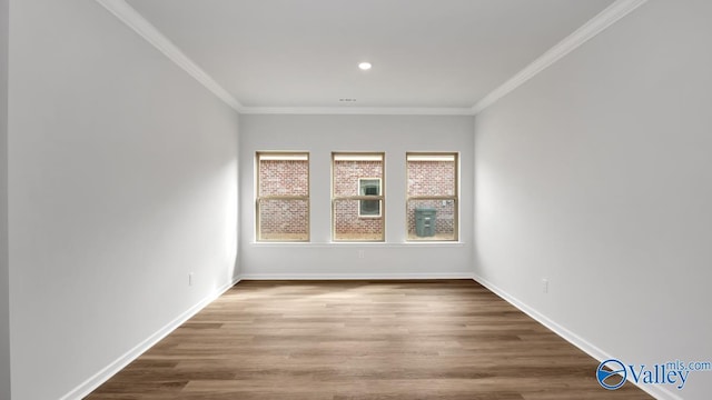 empty room with wood-type flooring and ornamental molding