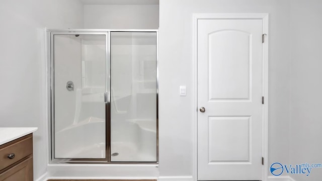 bathroom featuring vanity and a shower with shower door