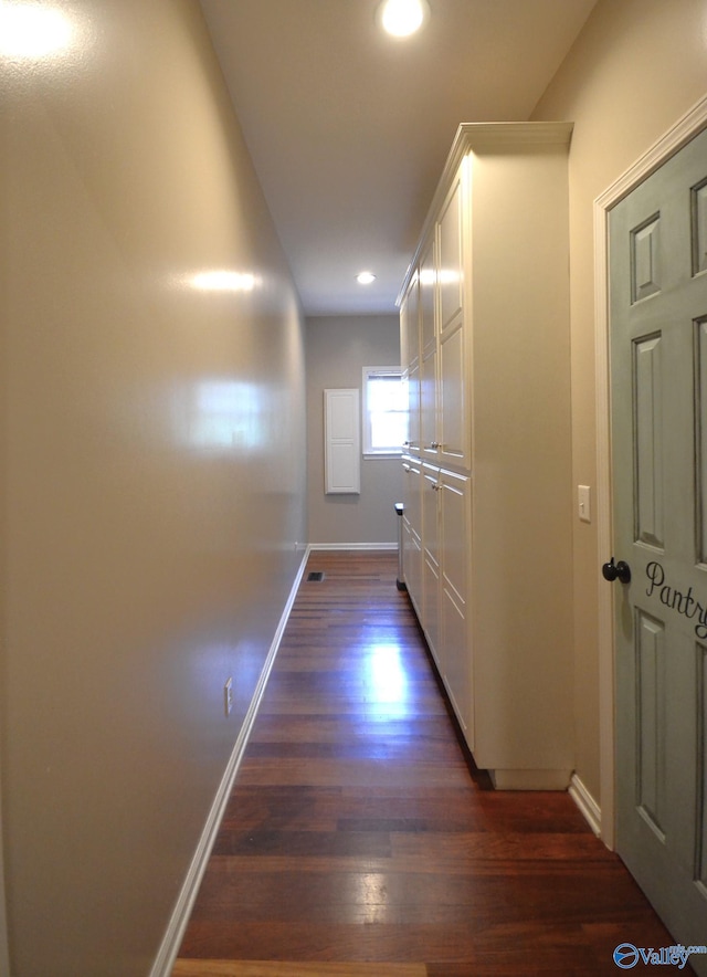 corridor with dark hardwood / wood-style flooring