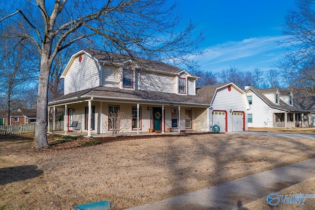 farmhouse with an attached garage, covered porch, fence, a gambrel roof, and driveway