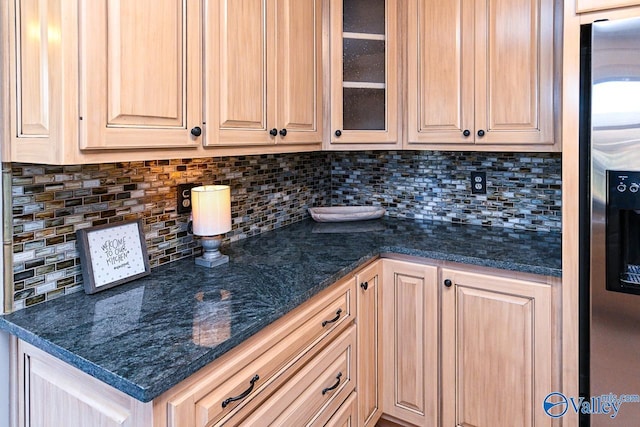 kitchen with light brown cabinetry, tasteful backsplash, glass insert cabinets, and stainless steel fridge with ice dispenser