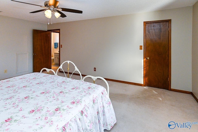 bedroom featuring a ceiling fan, light carpet, baseboards, and ensuite bathroom