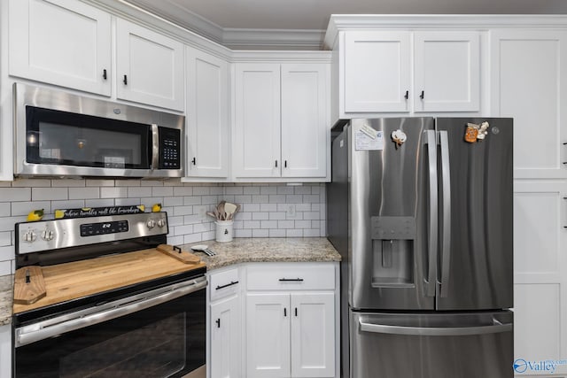 kitchen featuring stainless steel appliances, light stone countertops, white cabinets, and decorative backsplash