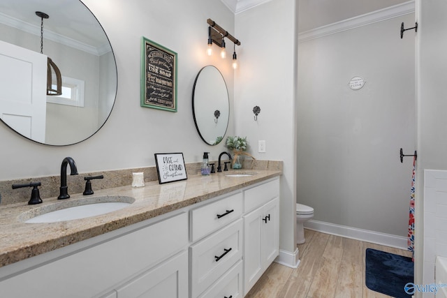 bathroom with wood-type flooring, vanity, toilet, and crown molding