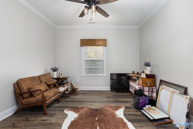 sitting room with dark wood-type flooring, ceiling fan, and crown molding