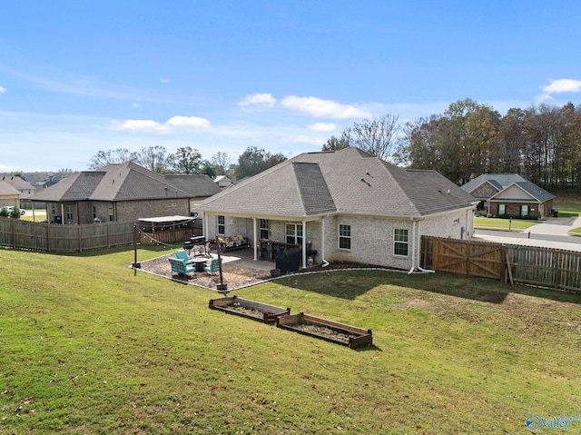 rear view of property featuring a patio and a yard