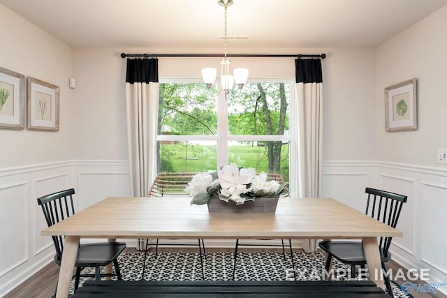 dining area with hardwood / wood-style floors and a chandelier