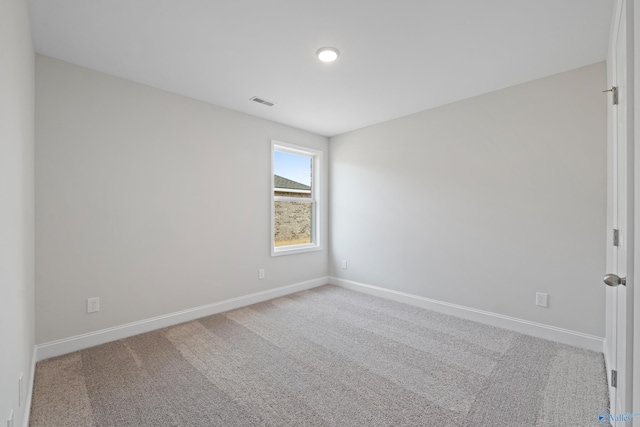 carpeted empty room with visible vents and baseboards