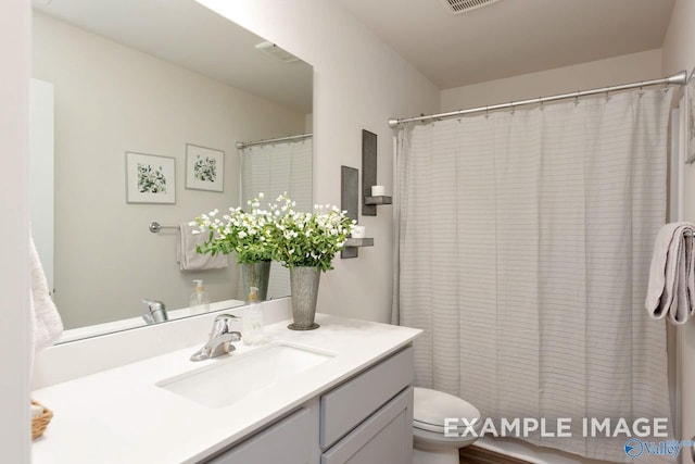 full bath featuring toilet, visible vents, a shower with shower curtain, and vanity