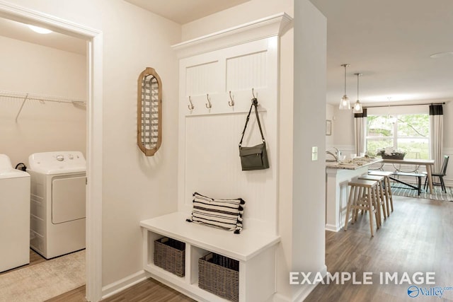 mudroom with washer and clothes dryer, wood finished floors, and baseboards