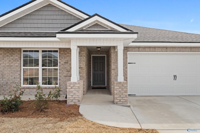 view of front facade with a garage, driveway, and a shingled roof