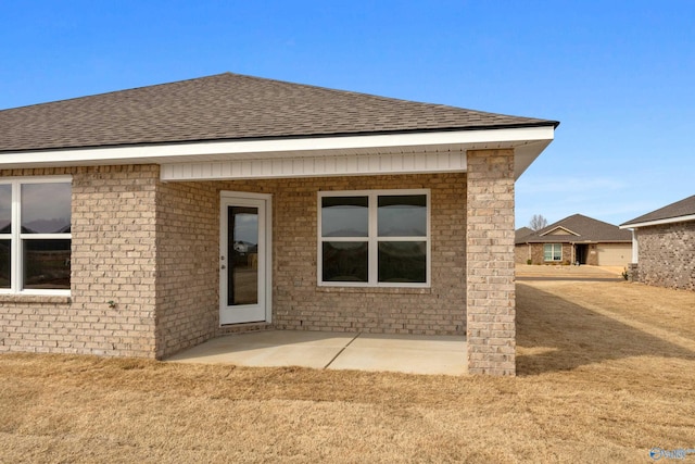 rear view of house with roof with shingles