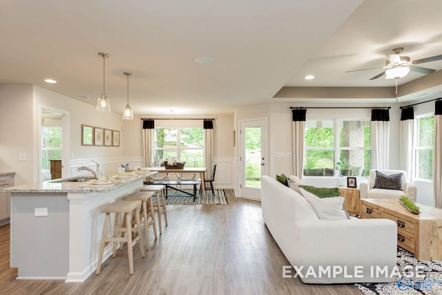 kitchen featuring dark wood-type flooring, sink, hanging light fixtures, ceiling fan, and light brown cabinetry