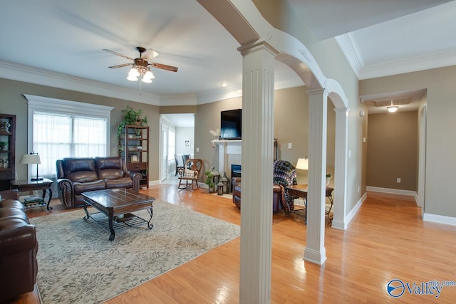 16675 Bellewood Dr, Athens, AL 35613 - living room with decorative columns, a ceiling fan, arched walkways, a fireplace, and light wood finished floors