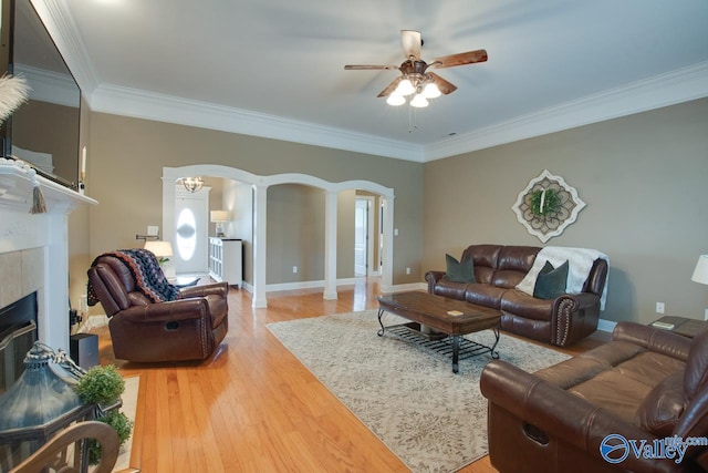 16675 Bellewood Dr, Athens, AL 35613 - living area featuring arched walkways, ceiling fan, crown molding, light wood finished floors, and a tile fireplace