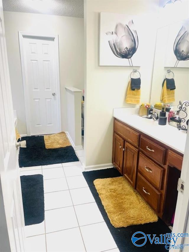 bathroom featuring vanity, tile patterned floors, and a textured ceiling