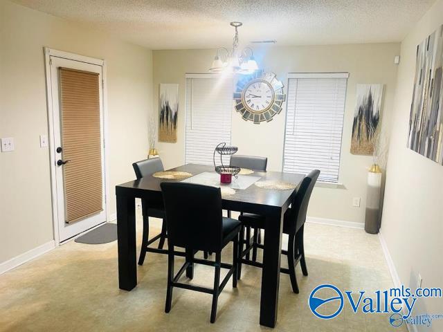 dining area with a textured ceiling and a notable chandelier