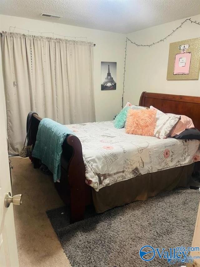 bedroom with carpet and a textured ceiling