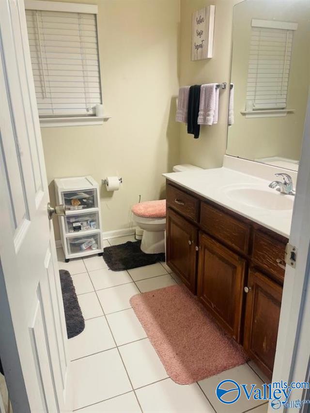 bathroom featuring vanity, tile patterned flooring, and toilet