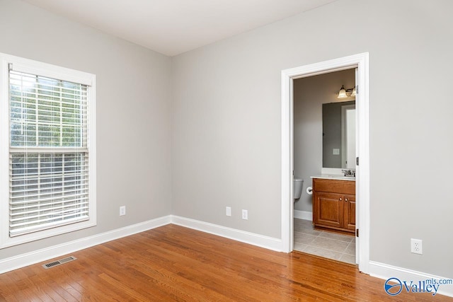 empty room with sink and light wood-type flooring